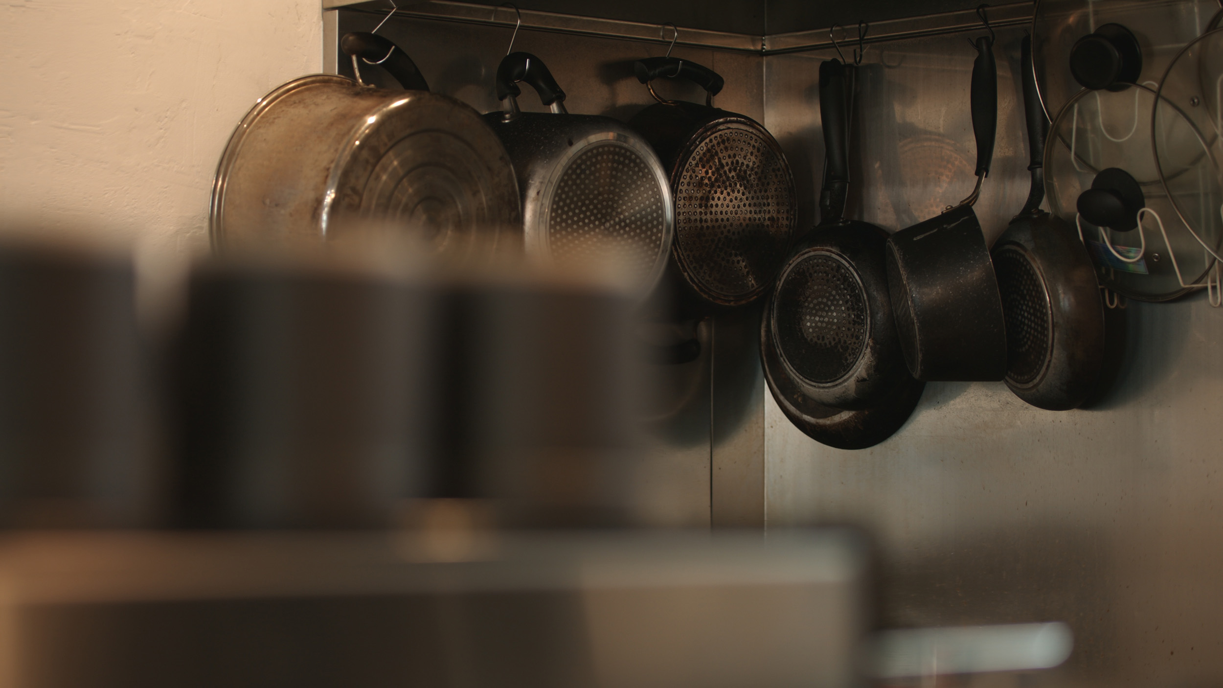 Hanging pots and pans on kitchen wall rack